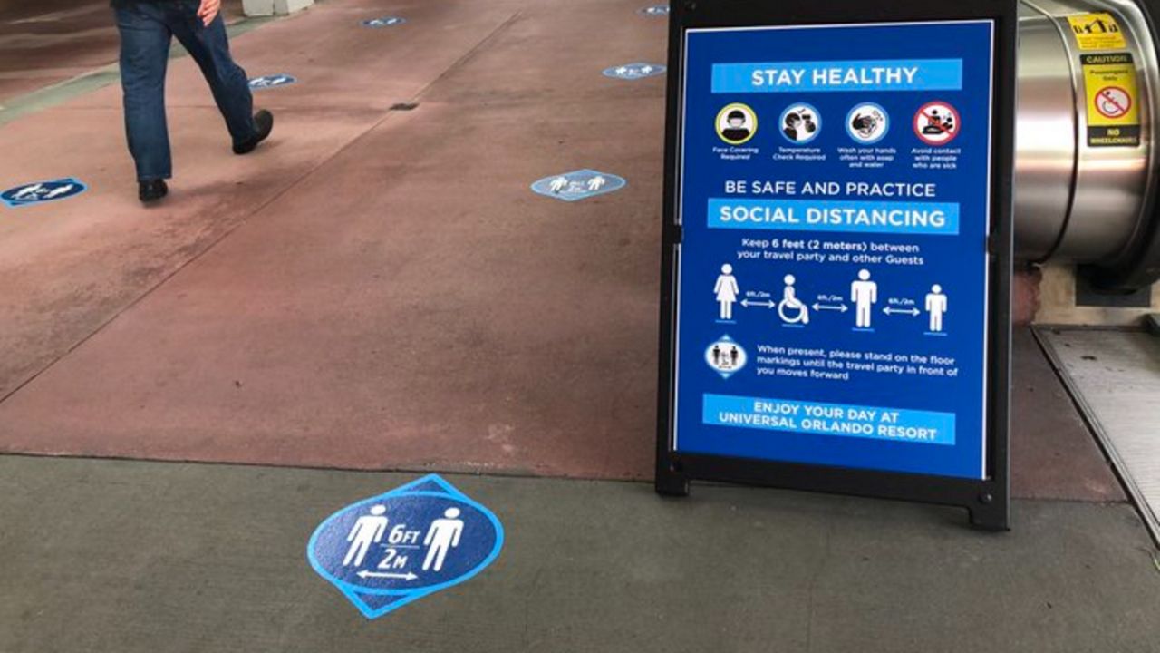 Sign at Universal Orlando remind visitors to keep at 6 feet of physical distancing. (Spectrum News/Ashley Carter)