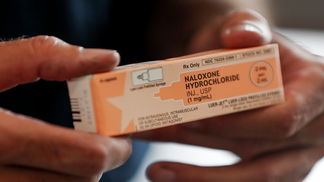 A fire medic holds a box containing naloxone hydrochloride, a potentially life-saving medication that can reverse drug overdoses. 