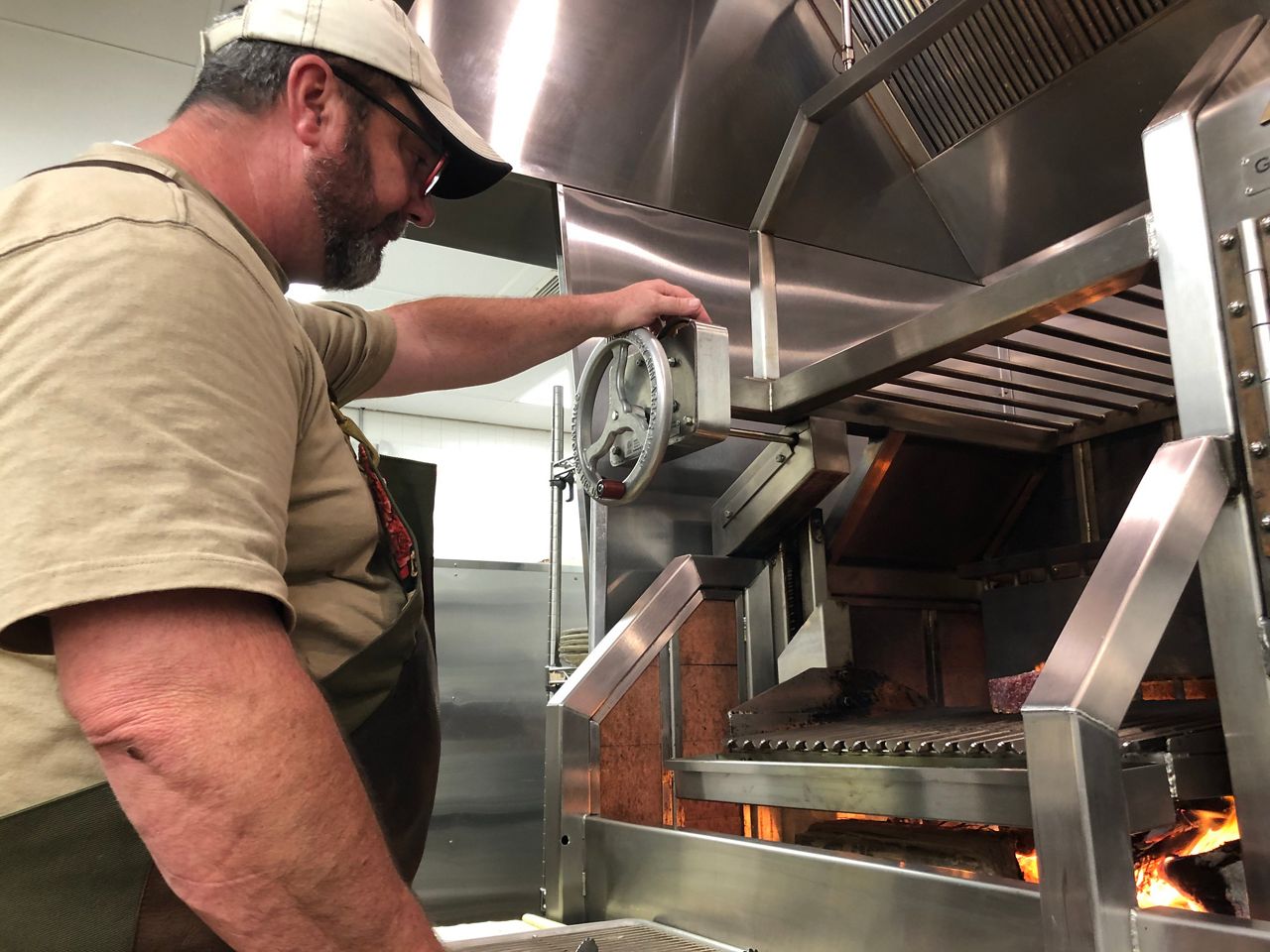 Pitmaster Darby Neaves works in his restaurant kitchen. (Bryan Boes/Spectrum News)