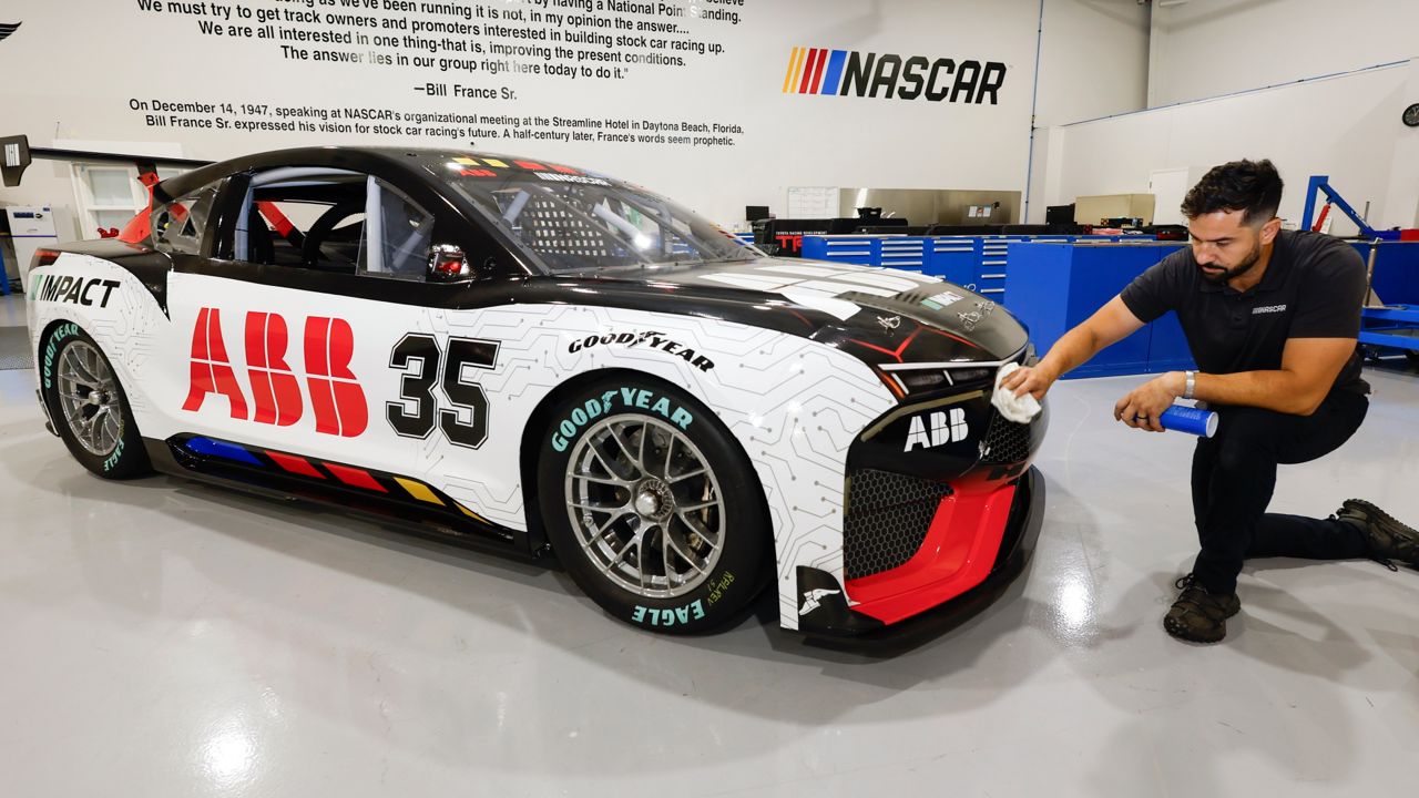 CJ Tobin, senior engineer of vehicle systems, cleans a prototype of the first electric racecar at the NASCAR R&D Center in Concord, N.C., Monday, July 1, 2024. 