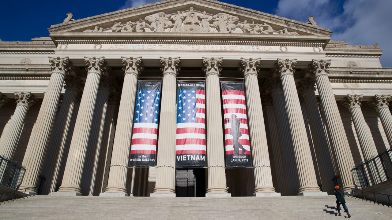 People walk up the steps even though the National Archives is closed with the partial government shutdown, Dec. 22, 2018 in Washington. While the Archives safeguards precious national documents such as the Declaration of Independence, the Constitution and the Bill of Rights, that's only the public face of their sprawling collection, which spans 13 billion pages of text and 10 million maps, charts and drawings, as well as tens of millions of photographs, films and other records. (AP Photo/Alex Brandon, File)