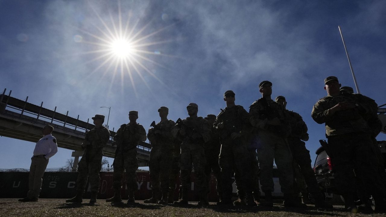 Members of the National Guard stand as Texas Gov. Greg Abbott and fellow governors hold a news conference along the Rio Grande to discuss Operation Lone Star and border concerns, Sunday, Feb. 4, 2024, in Eagle Pass, Texas. (AP Photo/Eric Gay, file)