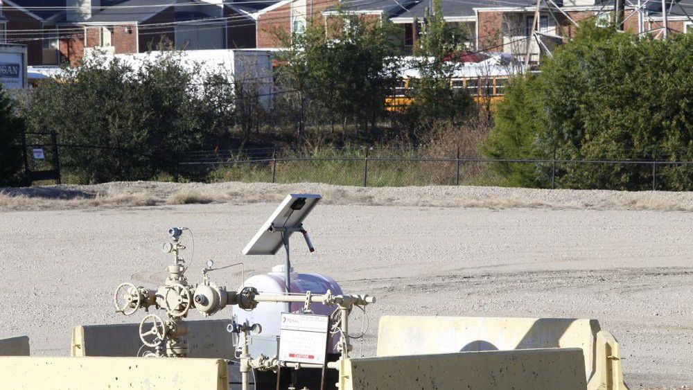 A natural gas well is juxtaposed with apartment buildings a few hundred feet away in Arlington, Texas, on Monday, Oct. 25, 2021. (AP Photo/Martha Irvine)