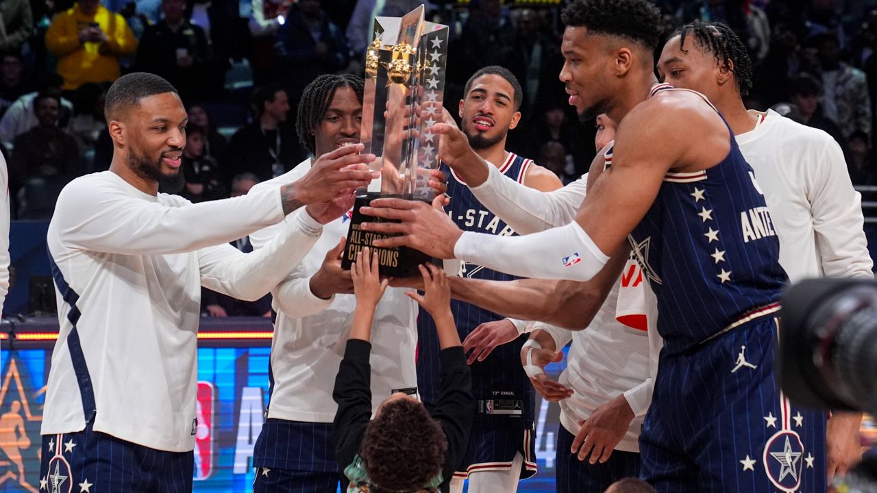 The East team, lead by captain Milwaukee Bucks forward Giannis Antetokounmpo, right, hoists the trophy after defeating the West 211-186 in the NBA All-Star basketball game in Indianapolis, Sunday, Feb. 18, 2024. (AP Photo/Darron Cummings)