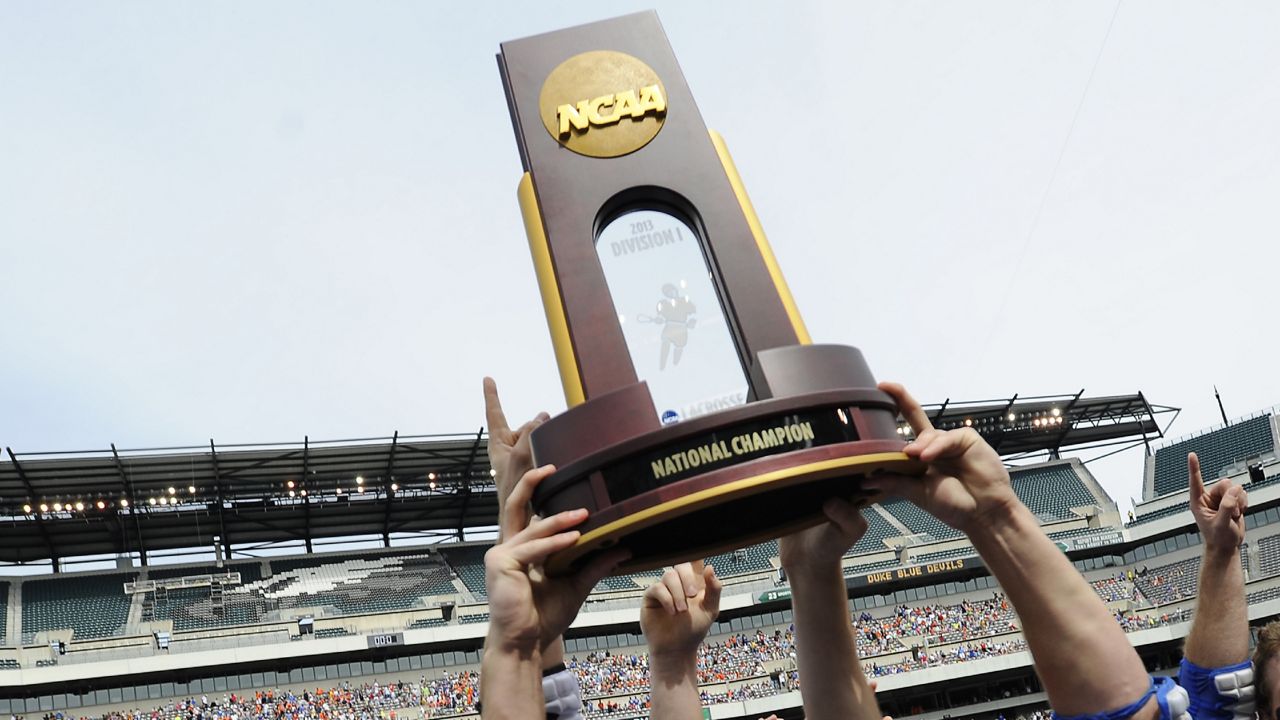 ncaa lacrosse championship trophy being held up