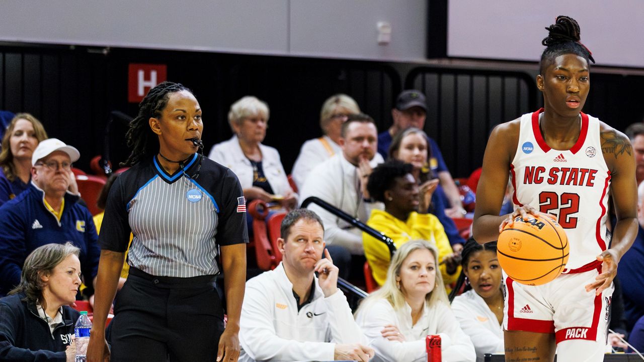 Official Tommi Paris, left, watches as North Carolina State's Saniya Rivers (22) handles the ball during the first half of a first-round college basketball game in the NCAA Tournament in Raleigh, N.C., Saturday, March 23, 2024. Paris was replaced at halftime by referee Angelica Suffren, who worked the earlier Green Bay-Tennessee game. NCAA representatives on-site didn’t provide a reason for the change. (AP Photo/Ben McKeown)