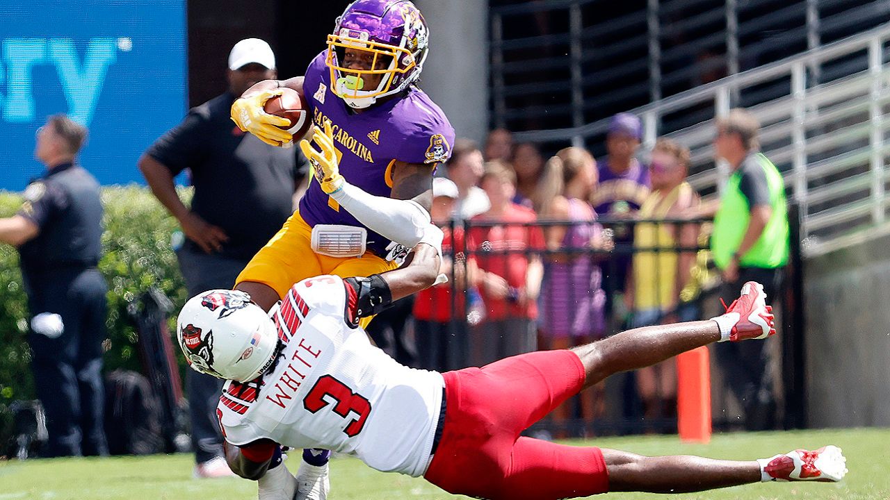 FILE - East Carolina's Jaylen Johnson (1) tries to avoid the tackle of North Carolina State's Aydan White (3) during the first half of an NCAA college football game in Greenville, N.C., Sept. 3, 2022. North Carolina state legislators advanced a bill Tuesday, June 4, 2024, that would require the state’s two largest public universities — the University of North Carolina at Chapel Hill and N.C. State University — to play each other annually in football and basketball and play three other top public system schools regularly. (AP Photo/Karl B DeBlaker, File)