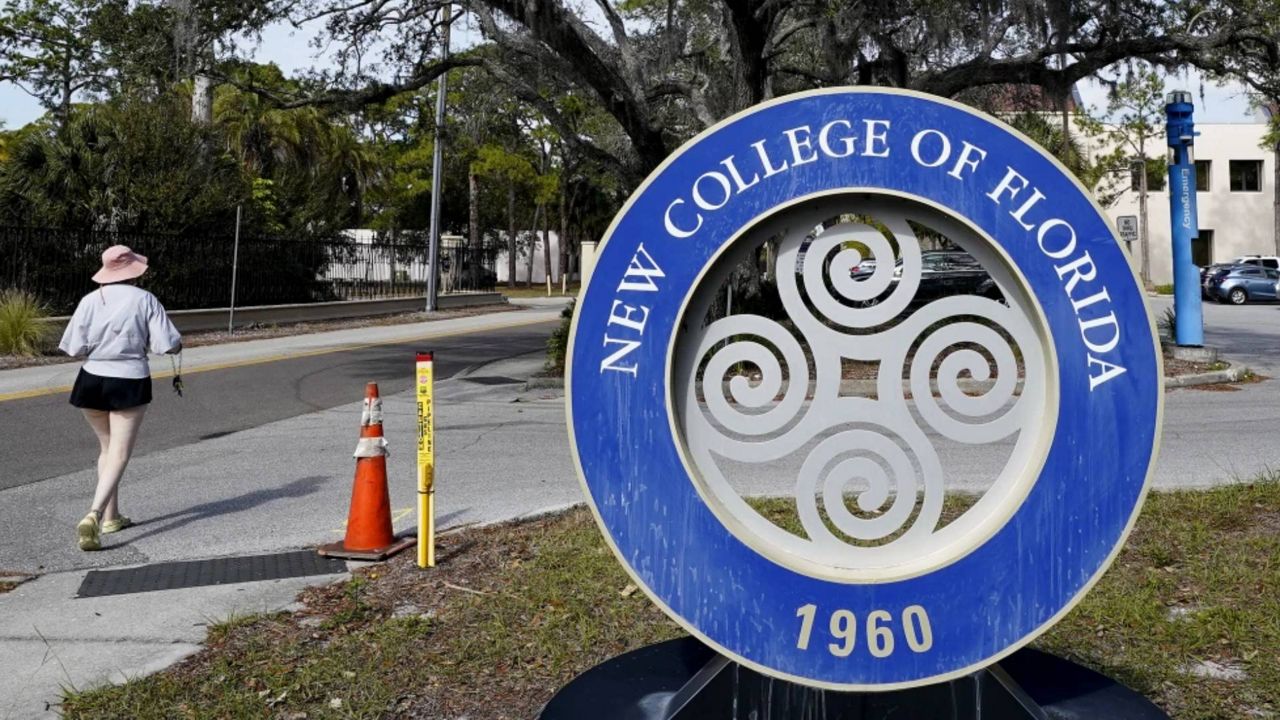 A student makes her way past the sign at New College of Florida, Jan. 20, 2023, in Sarasota, Fla. Attorneys for New College of Florida, the traditionally progressive public liberal arts college which was taken over by allies of Gov. Ron DeSantis as part of his “war on woke,” last week threatened to sue a group of former faculty members and students. It's because they have formed an alternative online institute named “Alt New College” after departing the school following the takeover. (AP Photo/Chris O'Meara, File)