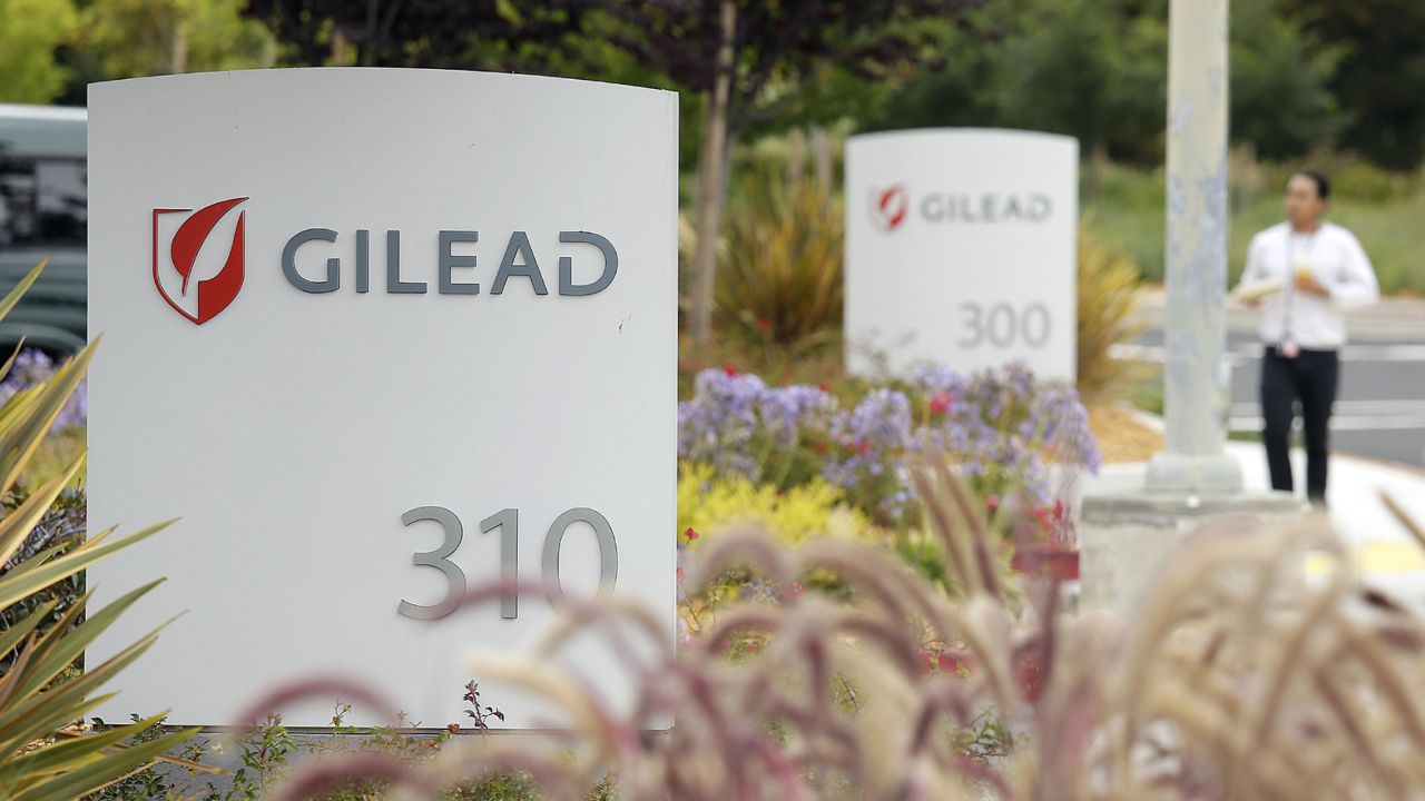 FILE - In this July 9, 2015, file photo, a man walks outside the headquarters of Gilead Sciences in Foster City, Calif. (AP Photo/Eric Risberg, File)