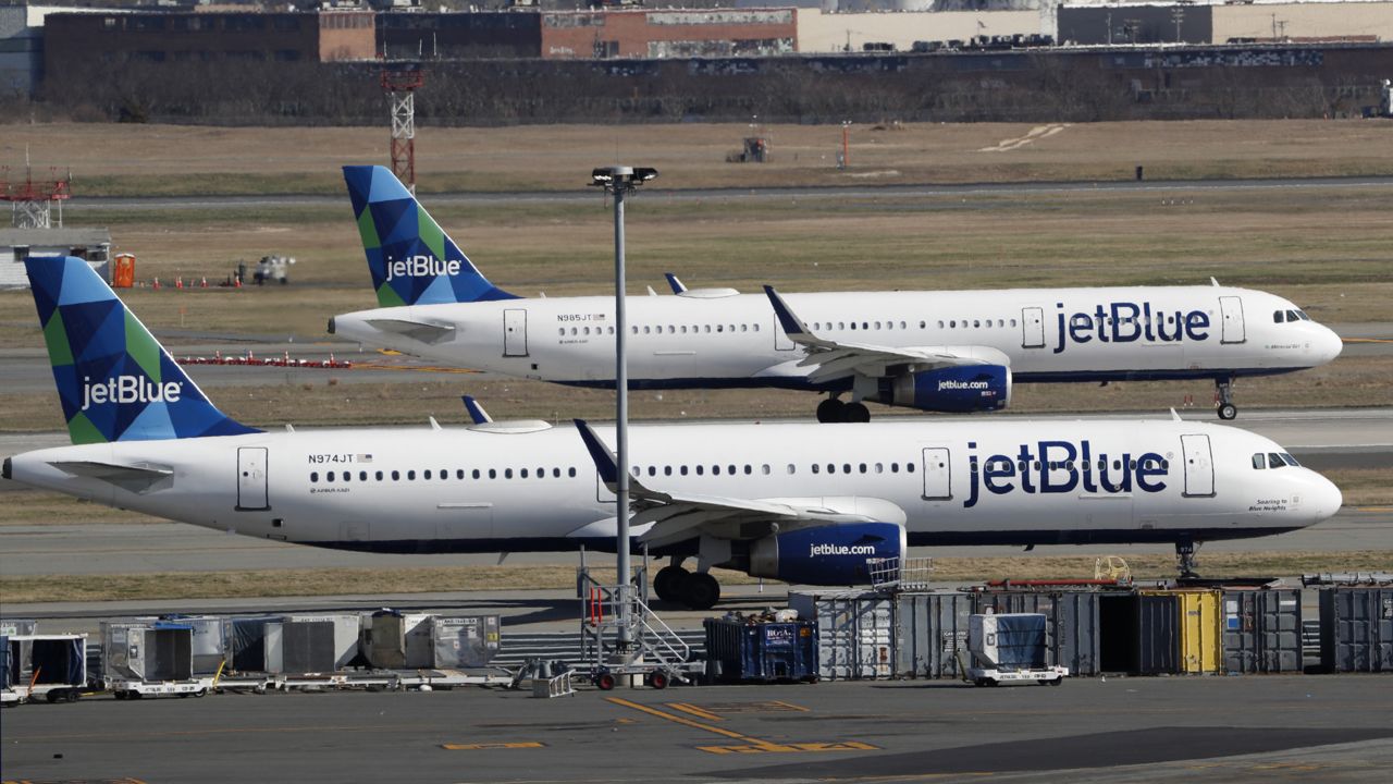 FILE: Two jetBlue airplanes line up in preparation for take-off, Saturday, March 14, 2020, at John F. Kennedy International Airport in New York. (AP Photo/Kathy Willens)