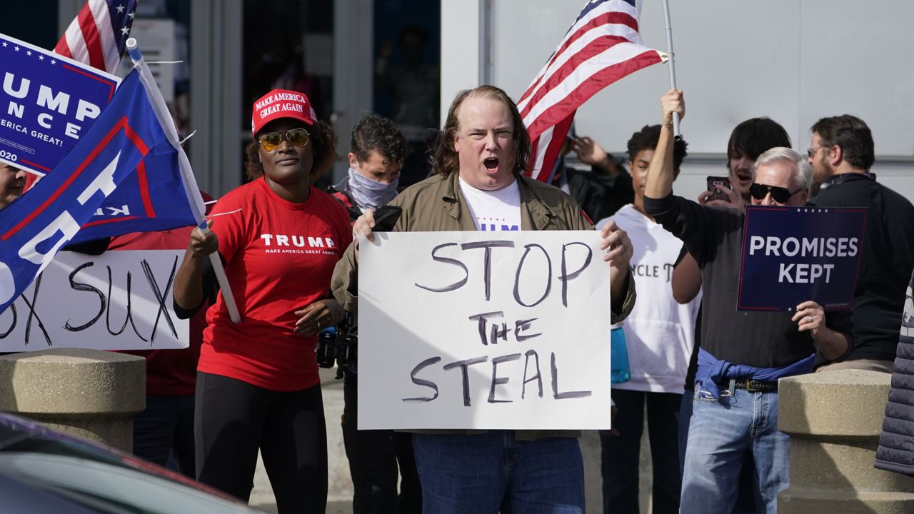Supports of President Donald Trump holds signs during a demonstration outside the State Farm Arena where Fulton County has a voting counting operation, Thursday, Nov. 5, 2020, in Atlanta. (AP Photo/John Bazemore)