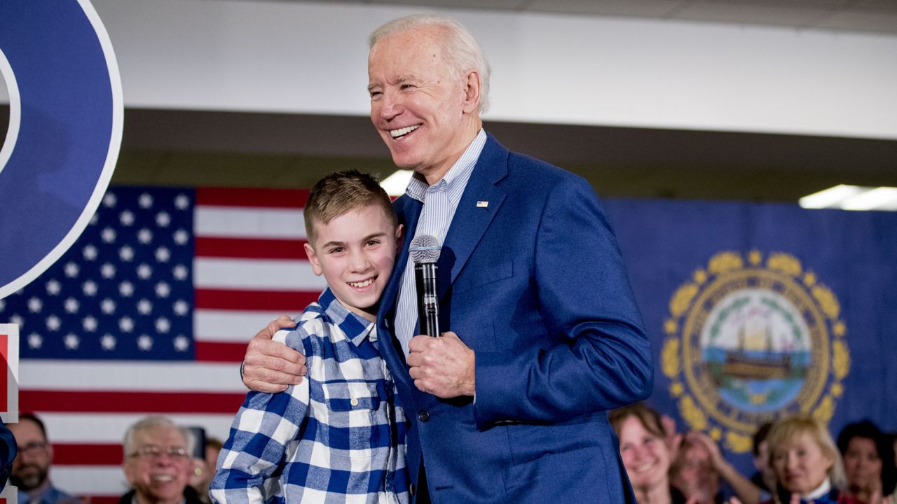 FILE: Democratic presidential candidate former Vice President Joe Biden hugs Brayden Harrington, 12, at a campaign stop at Cilford Community Curch, Monday, Feb. 10, 2020, in Gilford, N.H. (AP Photo/Andrew Harnik)
