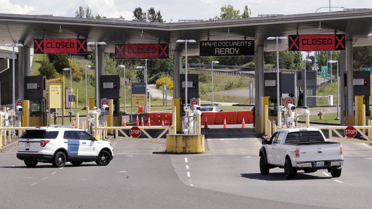 FILE: a truck from Canada heads to the single open lane heading into the U.S. at the Peace Arch border crossing in Blaine, Wash. (AP Photo/Elaine Thompson)