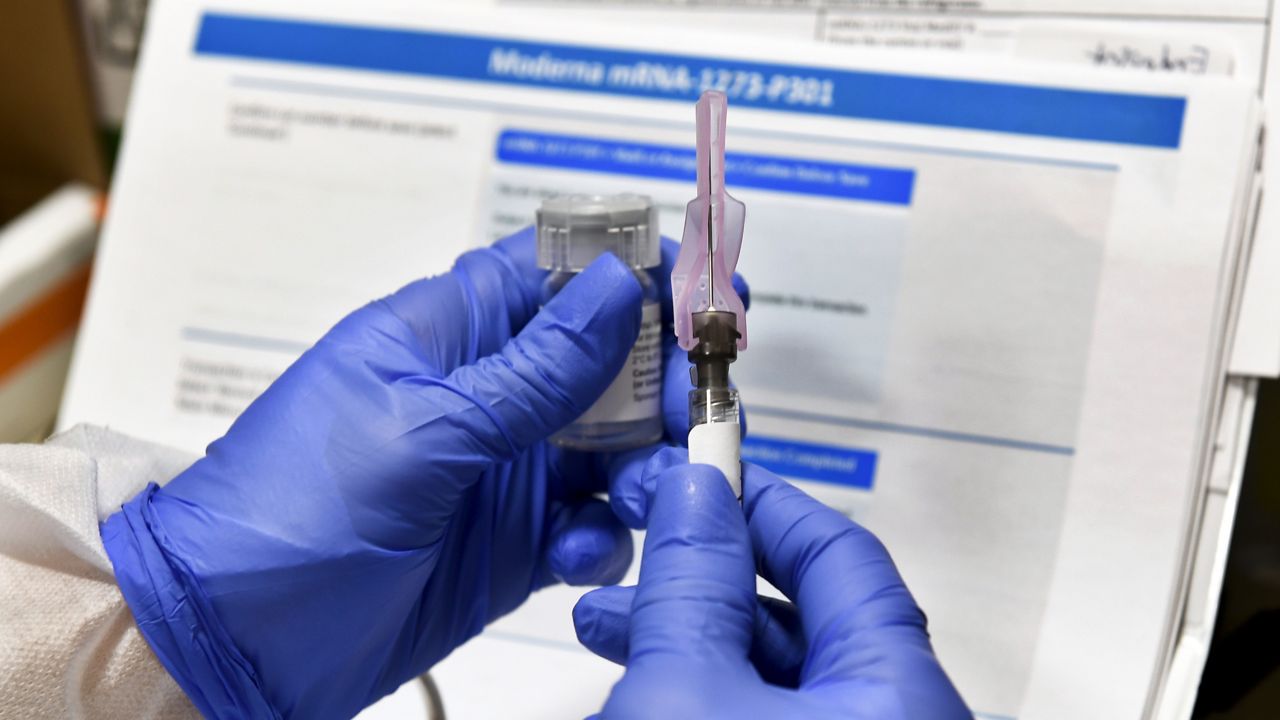 FILE - In this July 27, 2020, file photo, nurse Kathe Olmstead prepares a shot that is part of a possible COVID-19 vaccine, developed by the National Institutes of Health and Moderna Inc., in Binghamton, N.Y. (AP Photo/Hans Pennink, File)