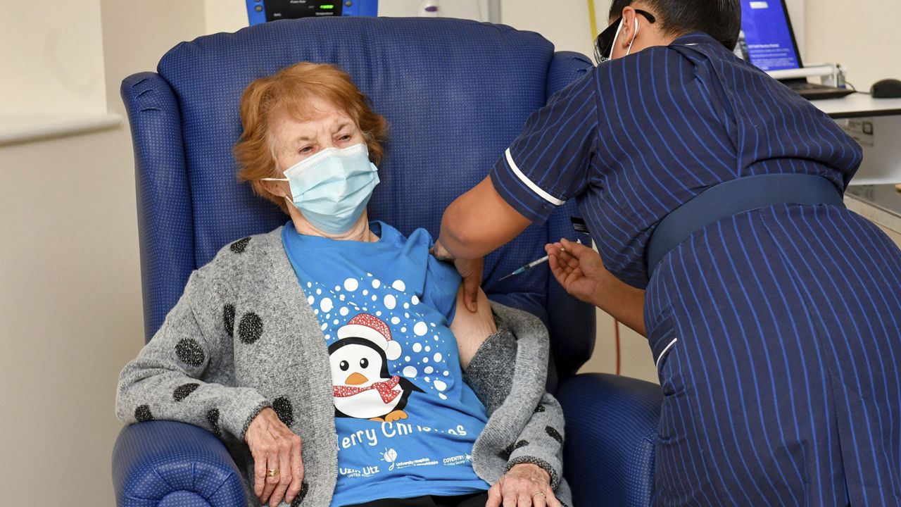 Margaret Keenan is the first patient in the UK to receive the Pfizer-BioNTech COVID-19 vaccine, administered by nurse May Parsons at University Hospital, Coventry, England, Tuesday Dec. 8, 2020. (Jacob King/Pool via AP)