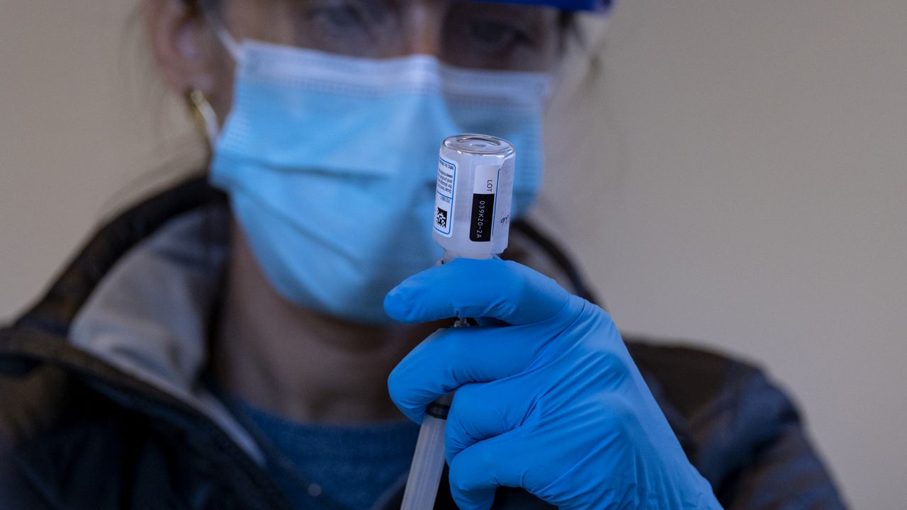FILE - In this Sunday, Jan. 10, 2021, file photo, Sarah Gonzalez of New York, a Nurse Practitioner, prepares a dose of the COVID-19 vaccine. (AP Photo/Craig Ruttle, File)