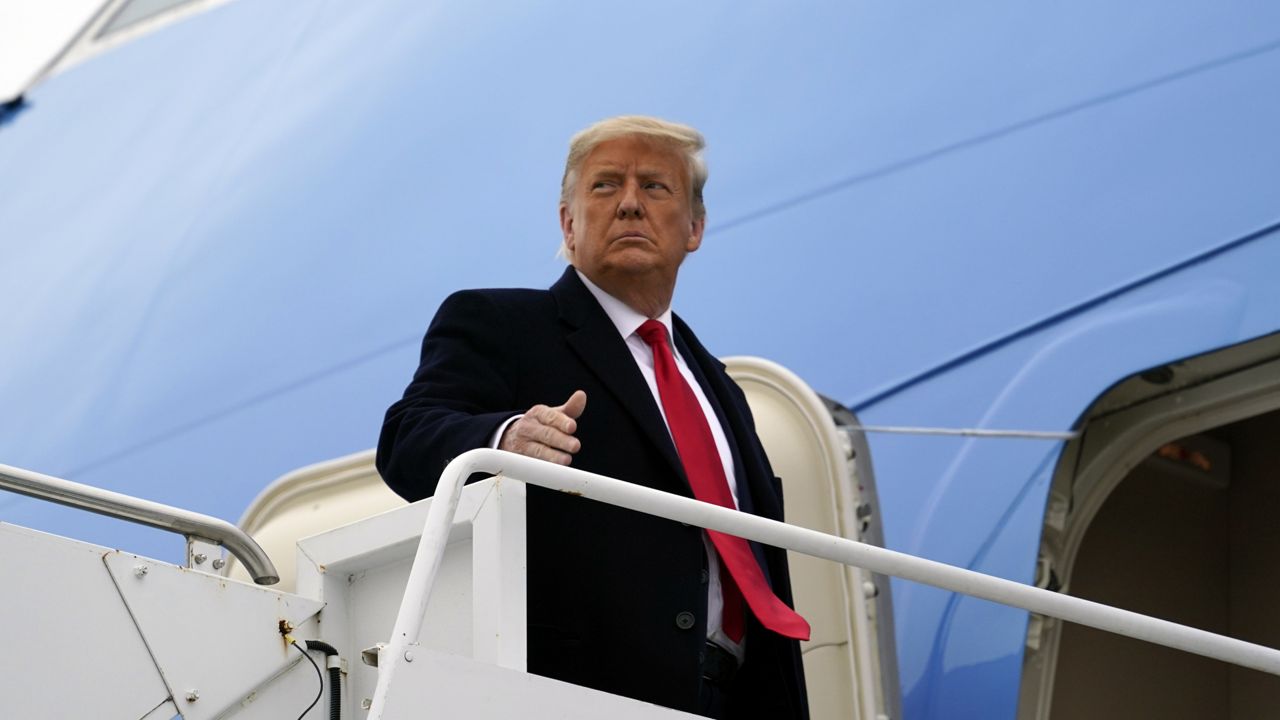 FILE: President Donald Trump gestures as he boards Air Force One upon arrival at Valley International Airport, Tuesday, Jan. 12, 2021, in Harlingen, Texas, after visiting a section of the border wall with Mexico in Alamo, Texas. (AP Photo/Alex Brandon)