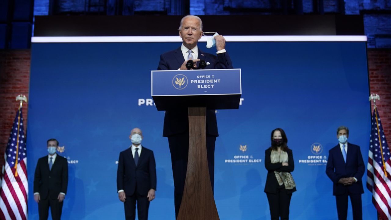 FILE: Biden removes his face mask as he arrives to introduce his nominees and appointees to key national security and foreign policy posts. (AP Photo/Carolyn Kaster)
