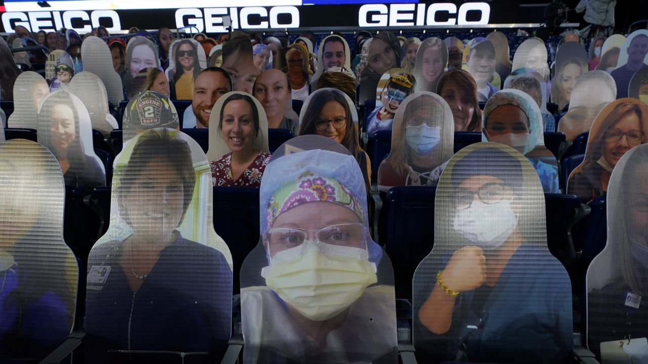FILE: Cutout photos of people, including first responders and healthcare workers, sit in seats in Gillette Stadium before an NFL football game. (AP Photo/Charles Krupa, File)