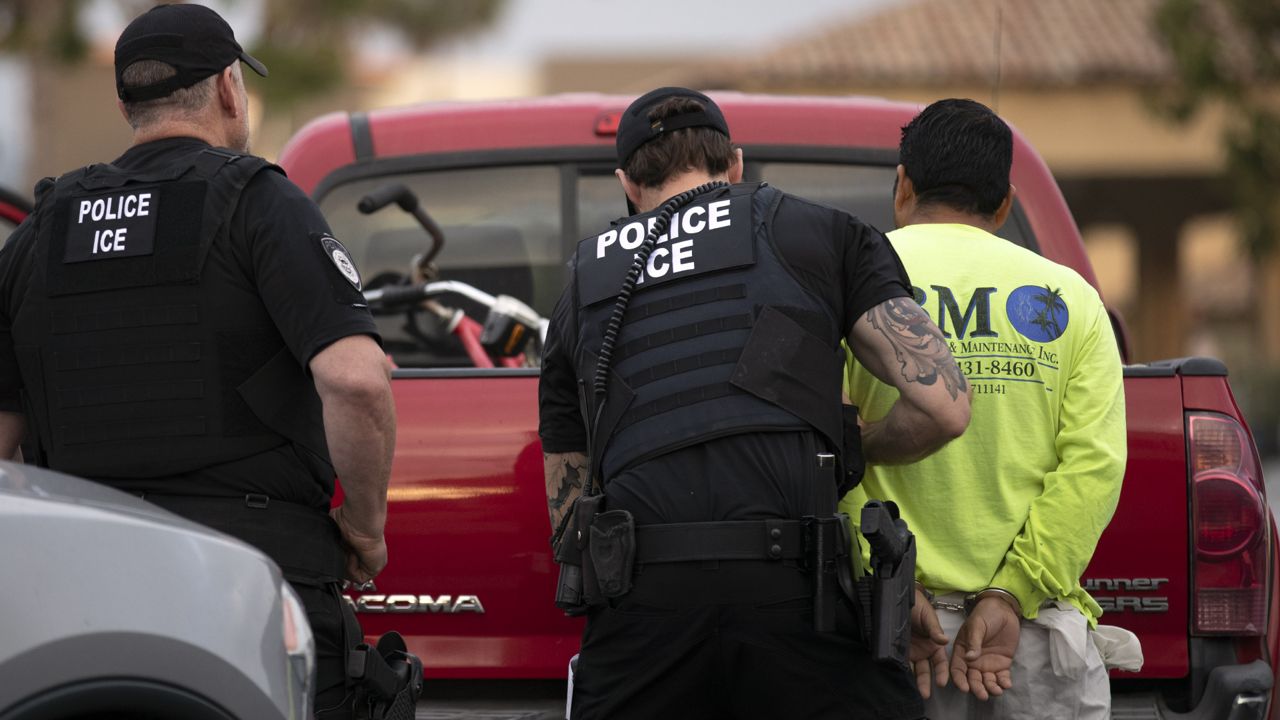 FILE - In this July 8, 2019, file photo, U.S. Immigration and Customs Enforcement (ICE) officers detain a man during an operation in Escondido, Calif. (AP Photo/Gregory Bull, File)