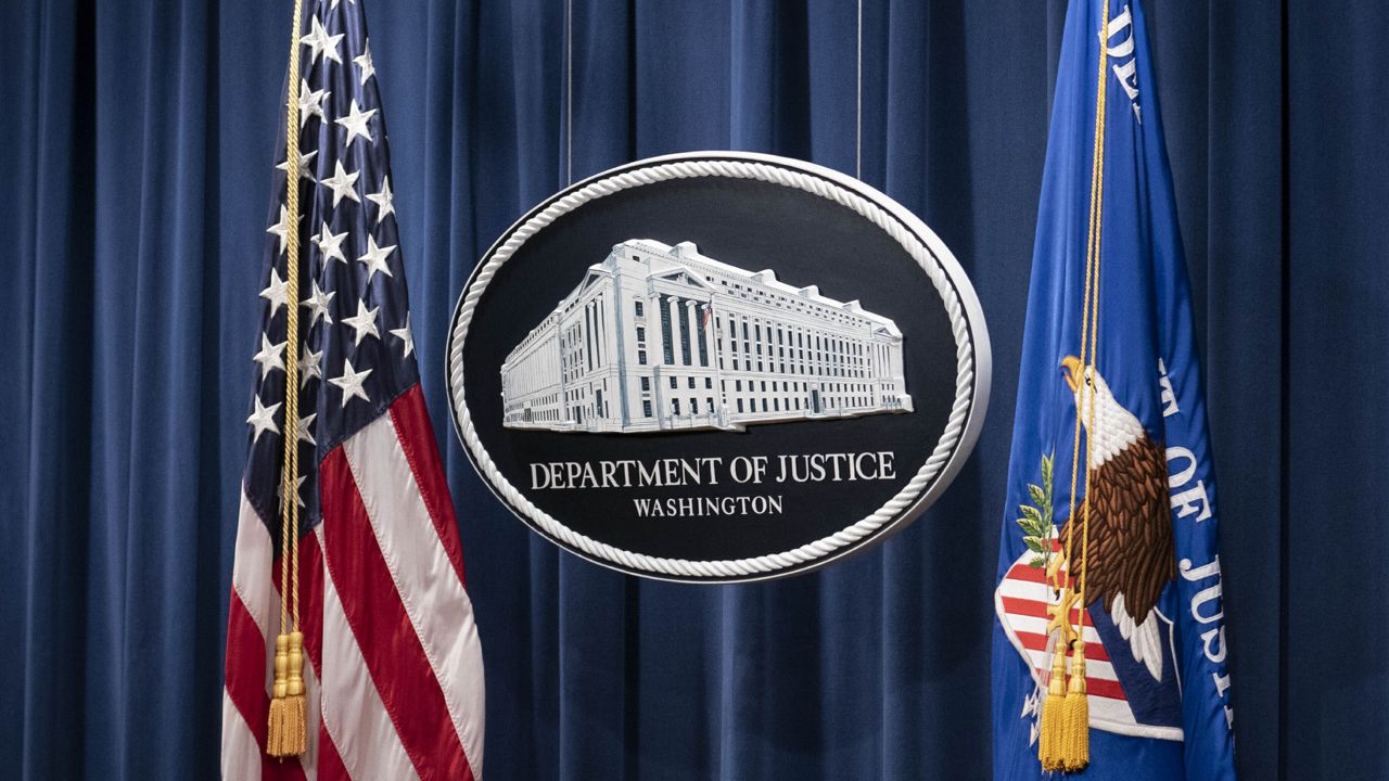 FILE - A sign for the Department of Justice ahead is seen of a news conference in Washington. (Sarah Silbiger/Pool via AP, File)