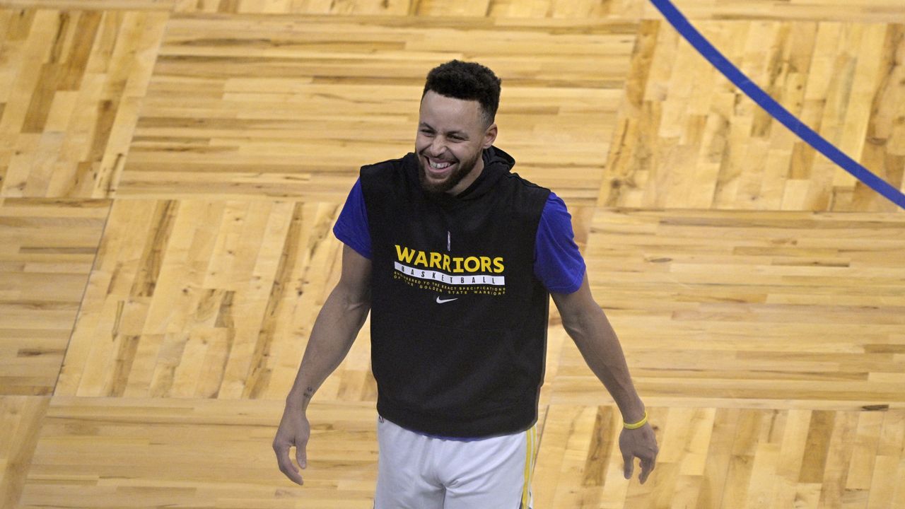 FILE: Golden State Warriors guard Stephen Curry has a laugh while warming up before an NBA basketball game against the Orlando Magic, Friday, Feb. 19, 2021, in Orlando, Fla. (AP Photo/Phelan M. Ebenhack)