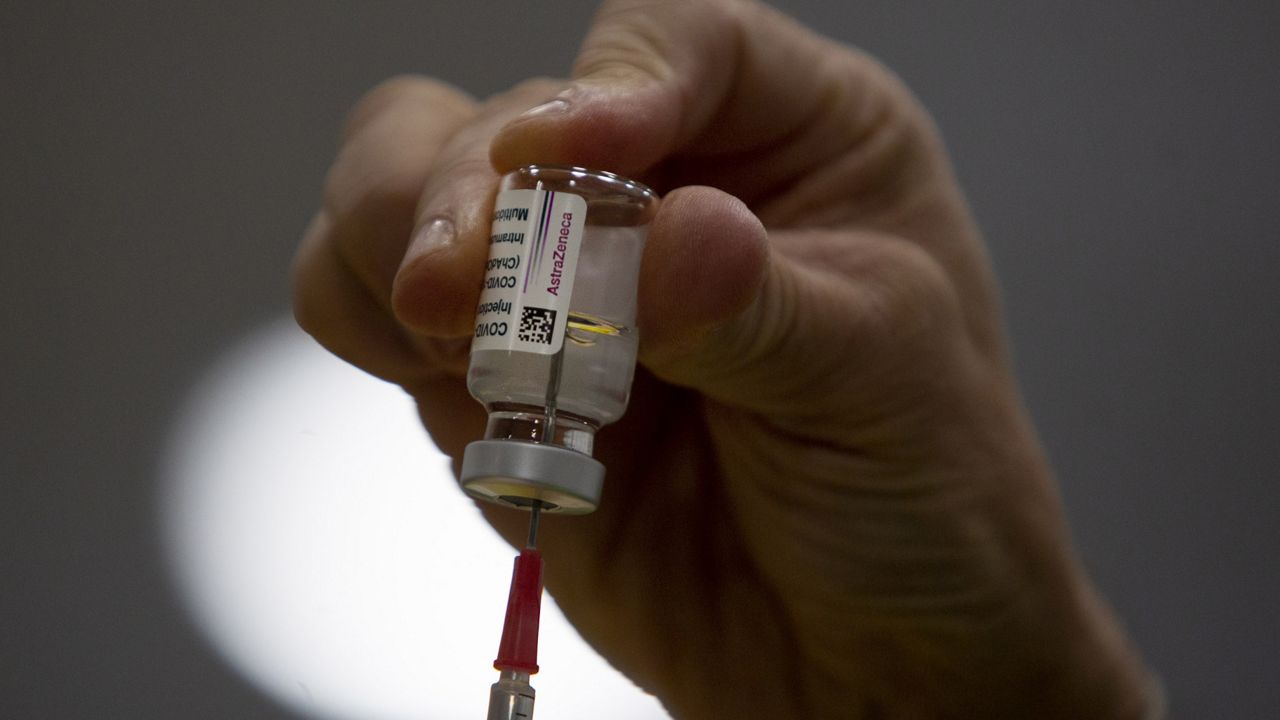 A pharmacist fills a syringe from a vial of the AstraZeneca COVID-19 vaccine at the Vaccine Village in Antwerp, Belgium on Tuesday, March 16, 2021. (AP Photo/Virginia Mayo)