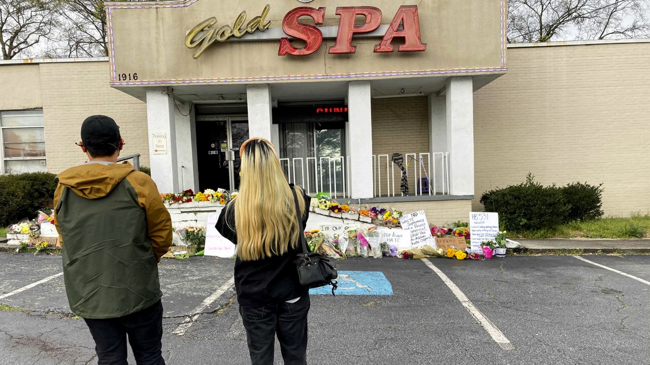 People view a make-shift memorial Friday, March 19, 2021, in Atlanta, in the aftermath of shootings. (AP Photo/Candice Choi)