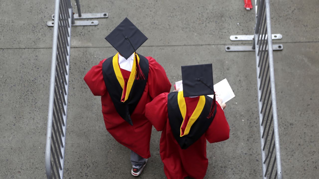 FILE - In this May 13, 2018, file photo, new graduates walk into the High Point Solutions Stadium before the start of the Rutgers University graduation ceremony. (AP Photo/Seth Wenig, File)