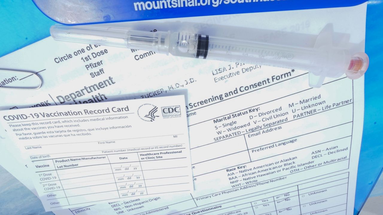 A syringe filled with the Johnson & Johnson's one-dose COVID-19 vaccine is seen net to a vaccination card. (AP Photo/Mary Altaffer)