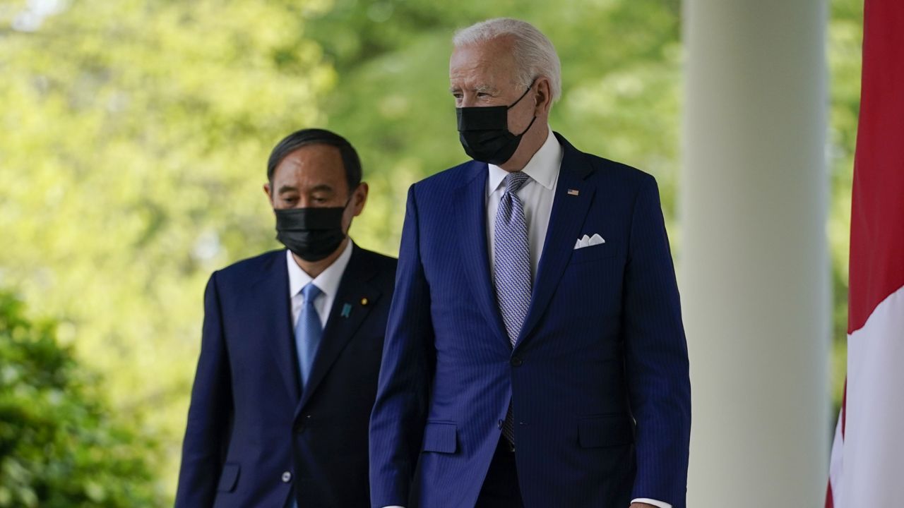 President Joe Biden, accompanied by Japanese Prime Minister Yoshihide Suga, walks from the Oval Office to speak at a news conference in the Rose Garden of the White House, Friday, April 16, 2021, in Washington. (AP Photo/Andrew Harnik)