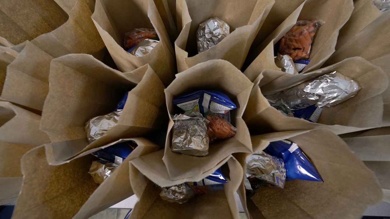 FILE: Bagged lunches await stapling before being distributed to students at the county's Tri-Plex Campus  on Wednesday, March 3, 2021 in Fayette, Miss. (AP Photo/Rogelio V. Solis)