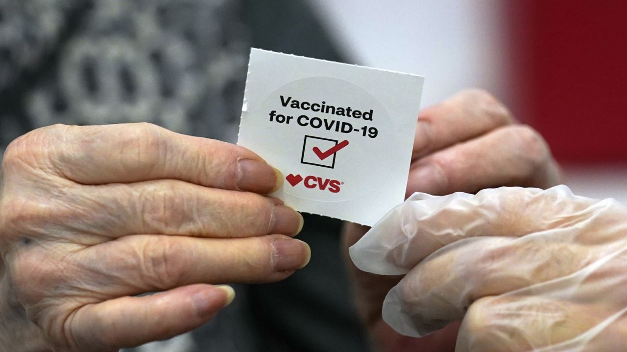 FILE: A patient receives a sticker after receiving a shot of the Moderna COVID-19 at a CVS Pharmacy branch Monday, March 1, 2021, in Los Angeles. (AP Photo/Marcio Jose Sanchez)