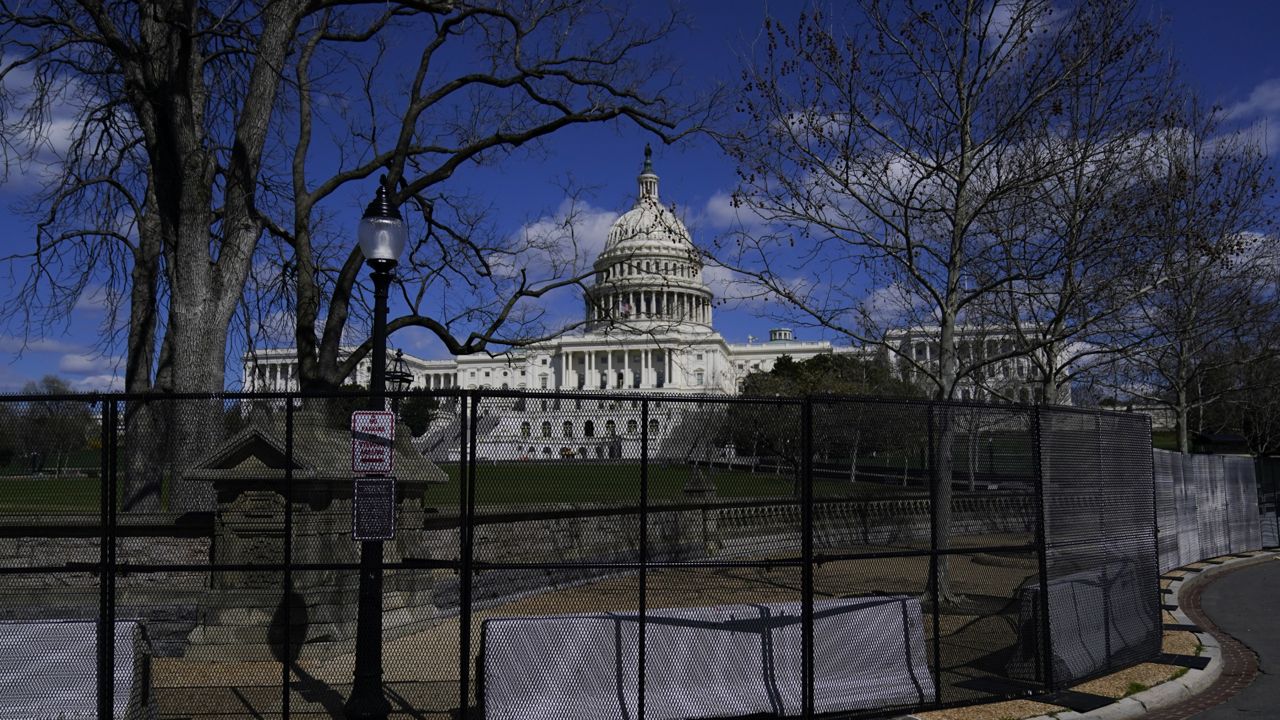 FILE: The U.S. Capitol is seen behind security fencing after a car that crashed into a barrier on Capitol Hill in Washington, Friday, April 2, 2021. (AP Photo/Carolyn Kaster)