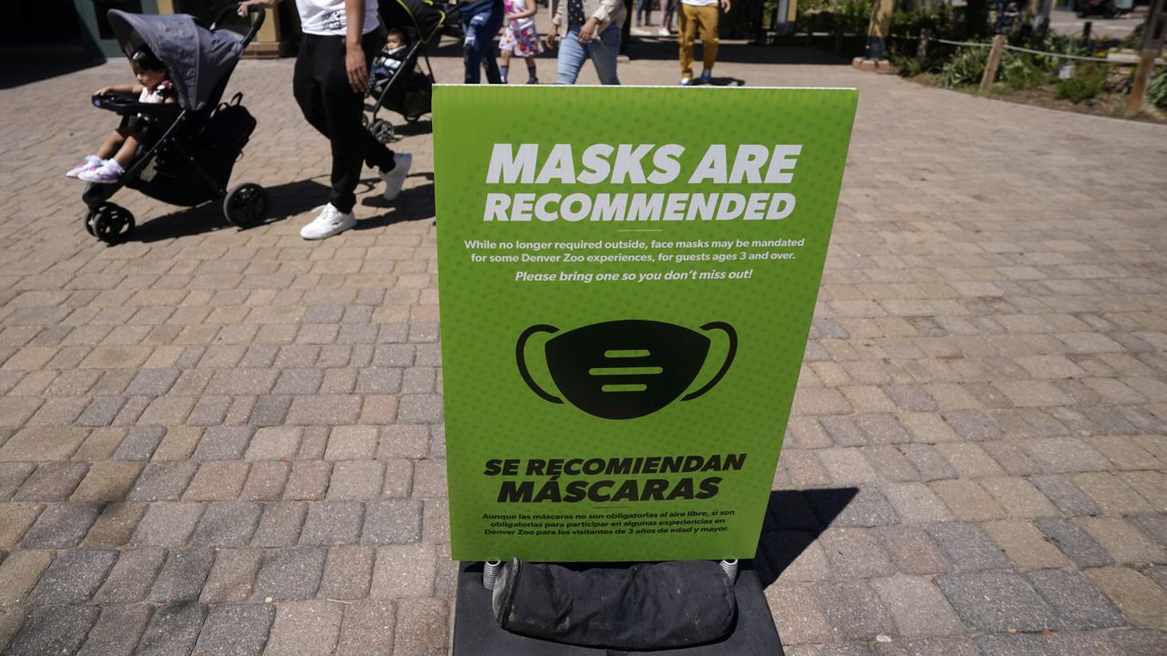 FILE - In this May 13, 2021, file photo, although no longer required outside, a sign advises visitors to wear masks at the Denver Zoo in Denver. (AP Photo/David Zalubowski, File)