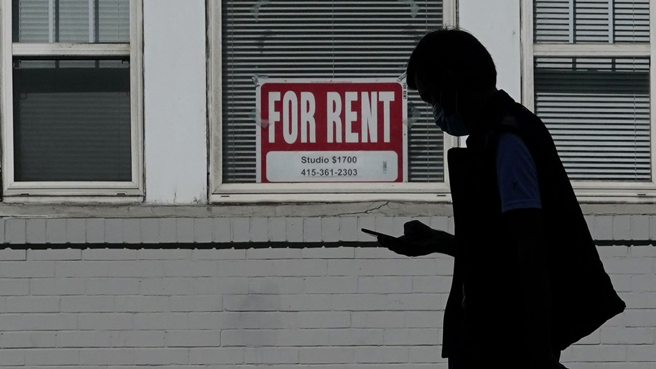 FILE - In this Oct. 20, 2020 file photo, a man walks in front of a For Rent sign in a window. (AP Photo/Jeff Chiu, File)