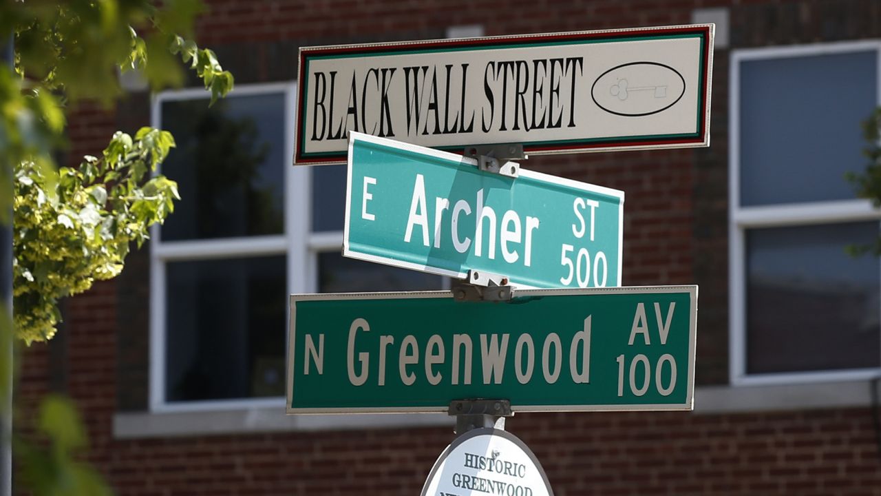 FILE - In this Monday, June 15, 2020, file photo, a sign marks the intersection of Greenwood Avenue and Archer Street, the former home of Black Wall Street, in Tulsa, Okla. (AP Photo/Sue Ogrocki)