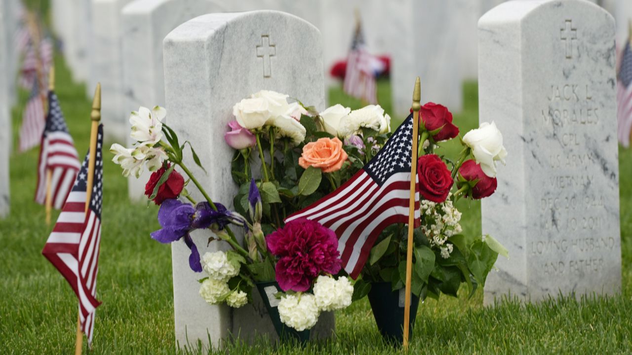 Tributes and flags mark gravestones at Fort Logan National Cemetery late Sunday, May 30, 2021, in Denver. (AP Photo/David Zalubowski)