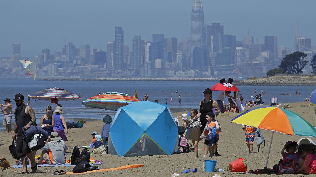 FILE - In this May 26, 2020, file photo, people congregate on Robert W. Crown Memorial State Beach with the San Francisco skyline as a backdrop in Alameda, Calif. (AP Photo/Ben Margot, File)