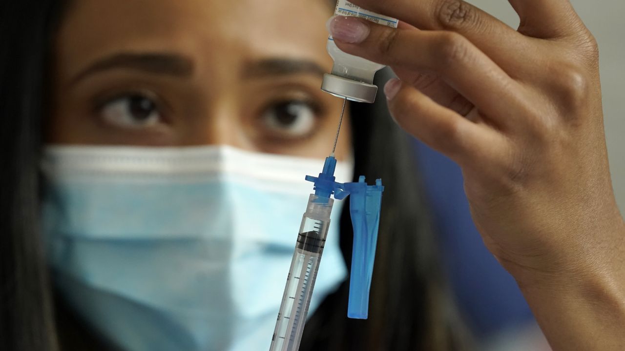 FILE: Licensed practical nurse Yokasta Castro draws a Moderna COVID-19 vaccine into a syringe at a mass vaccination clinic, Wednesday, May 19, 2021. (AP Photo/Steven Senne)