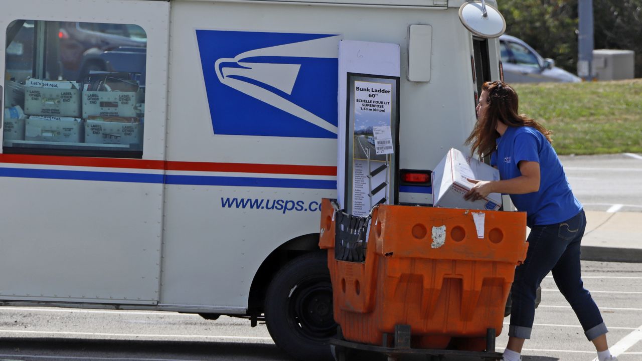 FILE: A postal worker loads a delivery vehicle at the United States Post Office in Cranberry Township, Pa., Wednesday, Aug. 19, 2020. (AP Photo/Gene J. Puskar)