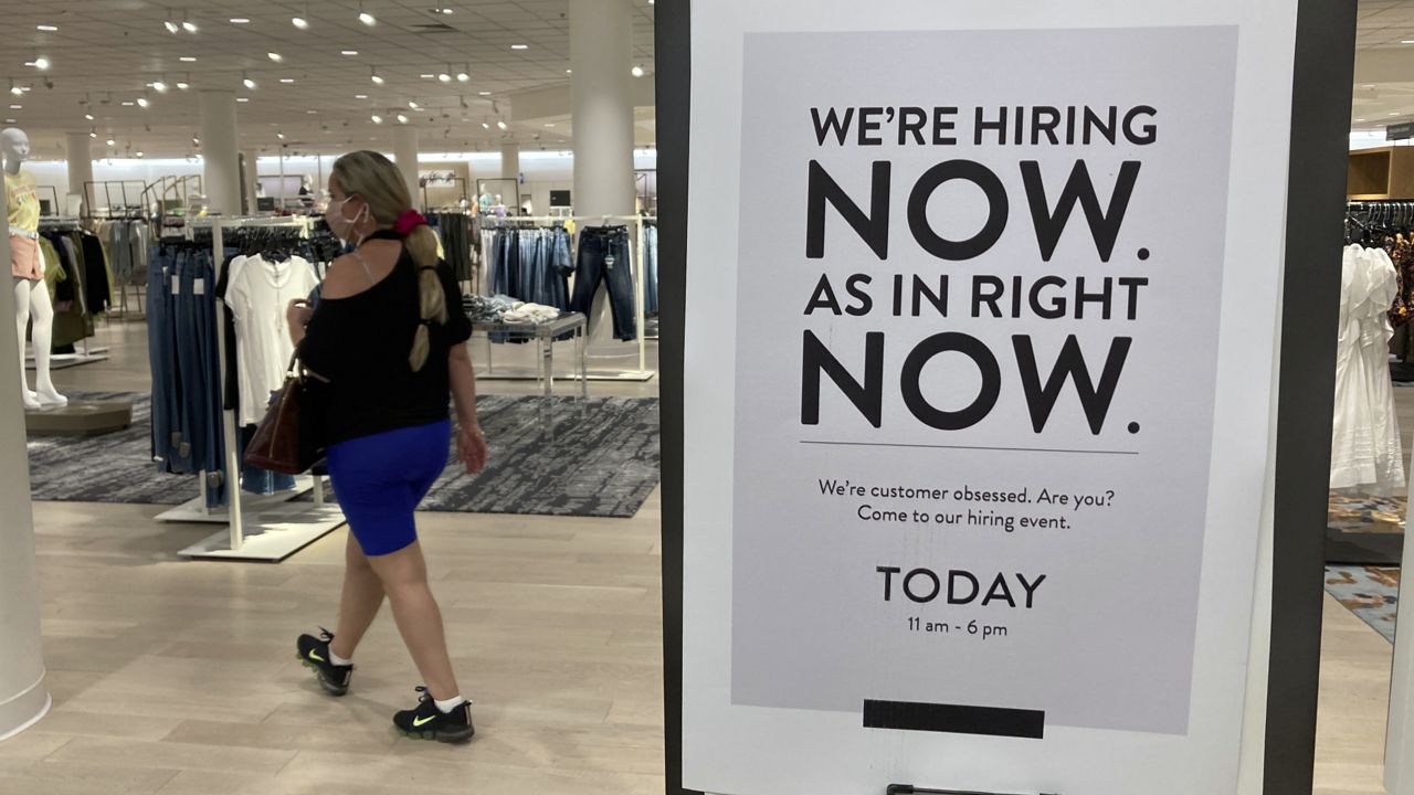 FILE - In this Friday, May 21, 2021 file photo, a customer walks behind a sign at a Nordstrom store seeking employees, in Coral Gables, Fla. (AP Photo/Marta Lavandier, File)