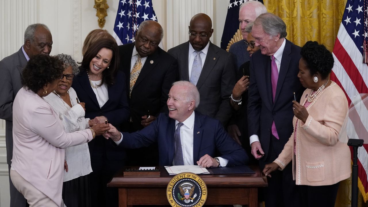 President Joe Biden hands a pen to Rep. Barbara Lee, D-Calif., after signing the Juneteenth National Independence Day Act, in the East Room of the White House, Thursday, June 17, 2021, in Washington. (AP Photo/Evan Vucci)