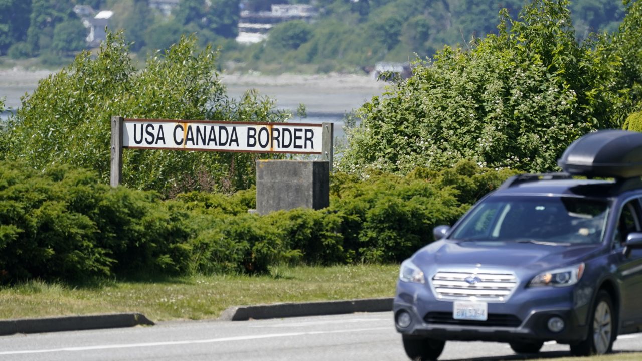 A car heads into the U.S. from Canada at the Peace Arch border crossing Tuesday, June 8, 2021, in Blaine, Wash. (AP Photo/Elaine Thompson)
