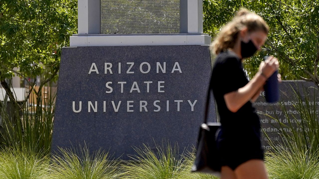 FILE: A pedestrian crosses an intersection on the campus of Arizona State University on Tuesday, Sept. 1, 2020, in Tempe, Ariz. (AP Photo/Matt York)