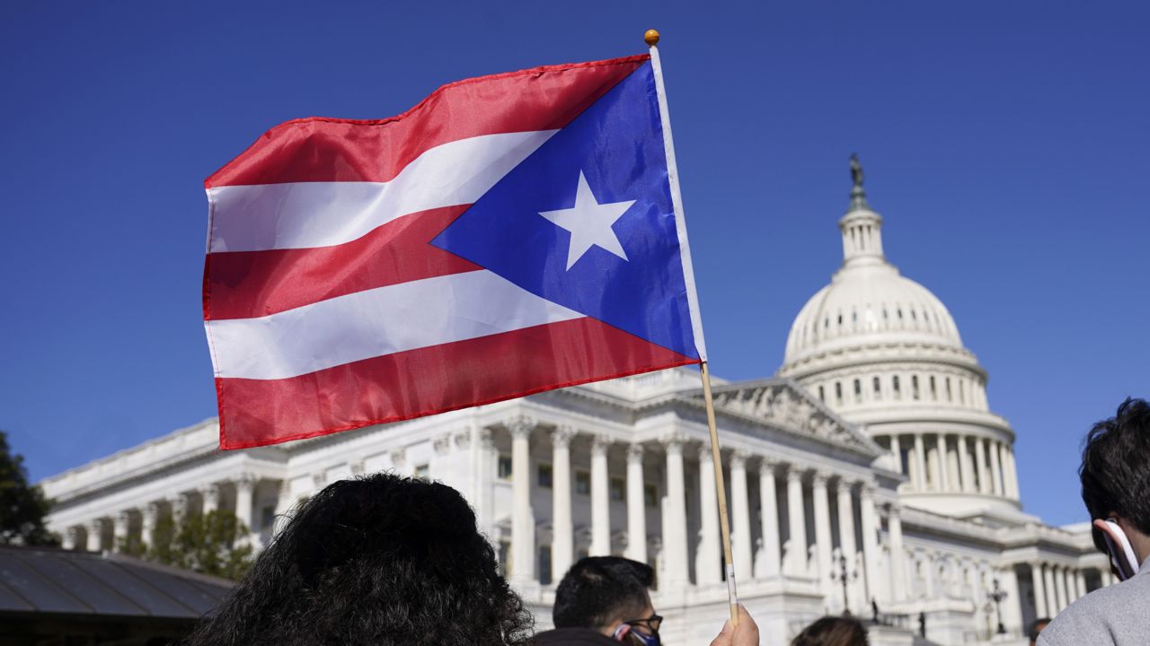 A woman waves the flag of Puerto Rico on Capitol Hill in Washington, Tuesday, March 2, 2021. (AP Photo/Patrick Semansky)