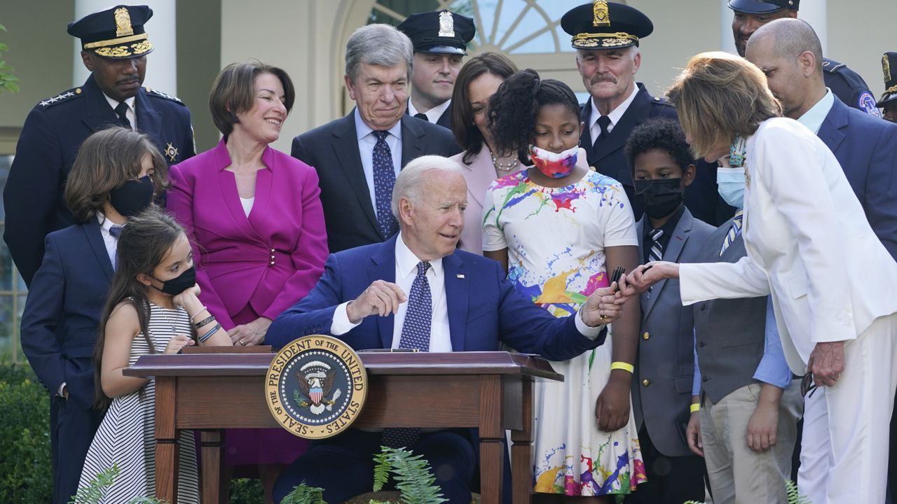 President Joe Biden hands a pen to House Speaker Nancy Pelosi of Calif., after he signed a bill in the Rose Garden of the White House, in Washington, Thursday, Aug. 5, 2021, that awards Congressional gold medals to law enforcement officers that protected members of Congress at the Capitol during the Jan. 6 riot. (AP Photo/Susan Walsh)