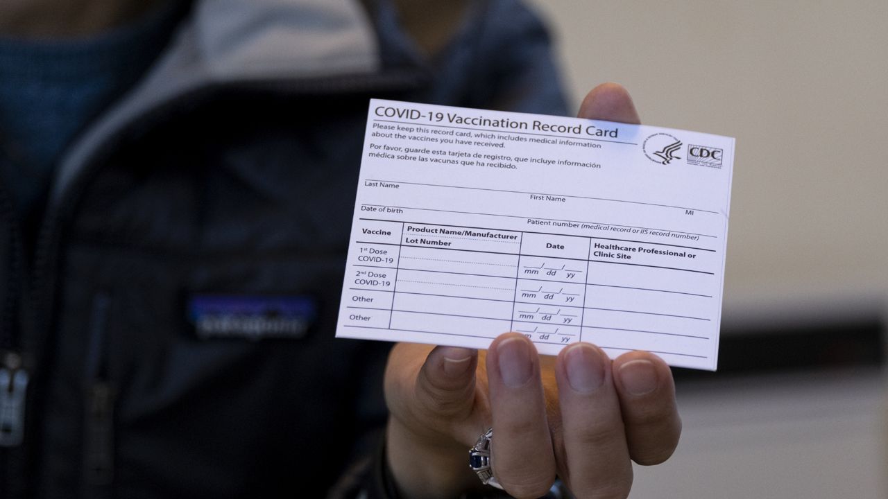 FILE - In this Jan. 10, 2021 file photo, Sarah Gonzalez of New York, a Nurse Practitioner, displays a COVID-19 vaccine card at a New York Health and Hospitals vaccine clinic. (AP Photo/Craig Ruttle, File)
