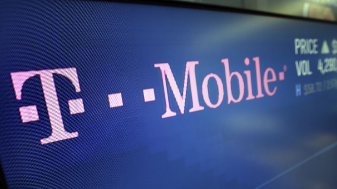 FILE - In this Feb. 14, 2018, file photo, the T-Mobile logo ppears on a screen at the Nasdaq MarketSite in New York. (AP Photo/Richard Drew, File)