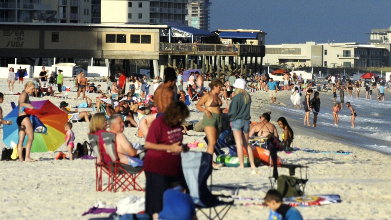 Beachgoers are shown on the coast at Gulf Shores, Ala., on Thursday, Aug. 12, 2021. (AP Photo/Jay Reeves)